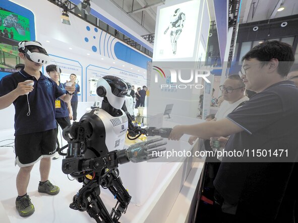 Spectators interact with humanoid robots at the 2024 World Robot Conference in Beijing, China, on August 22, 2024. 