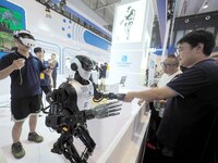 Spectators interact with humanoid robots at the 2024 World Robot Conference in Beijing, China, on August 22, 2024. (