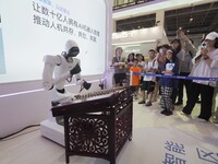 Visitors watch a ''humanoid robot'' play the dulcimer at the 2024 World Robot Conference in Beijing, China, on August 22, 2024. (