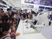 Visitors watch a performance of a ''calligraphy robot'' at the 2024 World Robot Conference in Beijing, China, on August 22, 2024. (