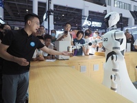 Visitors interact with a home service robot at the 2024 World Robot Conference in Beijing, China, on August 22, 2024. (