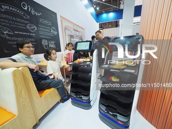 Visitors visit a ''food delivery robot'' at the 2024 World Robot Conference in Beijing, China, on August 22, 2024. (