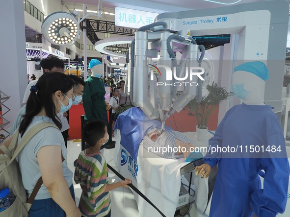 Visitors view a ''surgical robot'' at the 2024 World Robot Conference in Beijing, China, on August 22, 2024. 