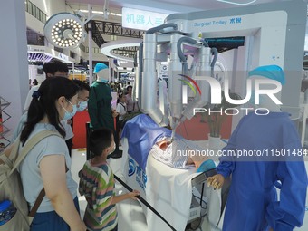 Visitors view a ''surgical robot'' at the 2024 World Robot Conference in Beijing, China, on August 22, 2024. (