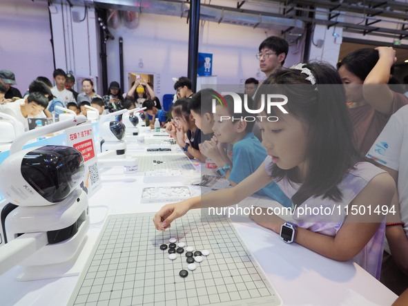 A spectator plays with a ''Go robot'' at the 2024 World Robot Conference in Beijing, China, on August 22, 2024. 