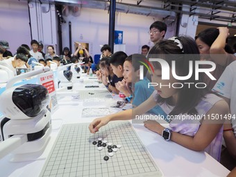 A spectator plays with a ''Go robot'' at the 2024 World Robot Conference in Beijing, China, on August 22, 2024. (