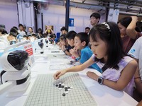 A spectator plays with a ''Go robot'' at the 2024 World Robot Conference in Beijing, China, on August 22, 2024. (