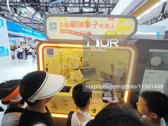 Visitors view a ''Jianbing robot'' at the 2024 World Robot Conference in Beijing, China, on August 22, 2024. 