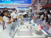 Visitors visit a ''picking and weighing robot'' at the 2024 World Robot Conference in Beijing, China, on August 22, 2024. (