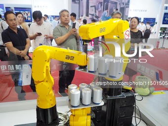 Visitors visit the ''three-machine linkage winding can'' at the 2024 World Robot Conference in Beijing, China, on August 22, 2024. (