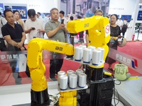 Visitors visit the ''three-machine linkage winding can'' at the 2024 World Robot Conference in Beijing, China, on August 22, 2024. (