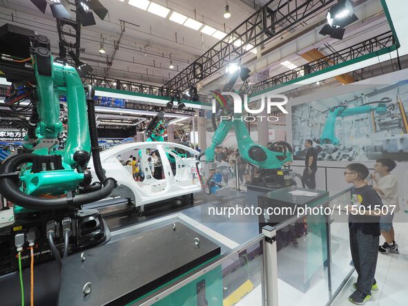 Visitors visit the ''four-machine spot Welding Exhibition station'' at the 2024 World Robot Conference in Beijing, China, on August 22, 2024...