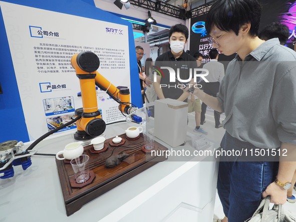 Visitors visit a ''tea art robot'' at the 2024 World Robot Conference in Beijing, China, on August 22, 2024. 