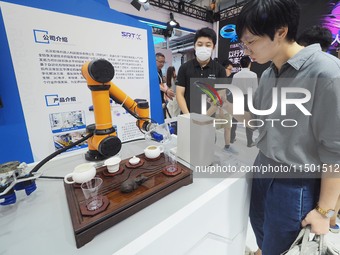 Visitors visit a ''tea art robot'' at the 2024 World Robot Conference in Beijing, China, on August 22, 2024. (