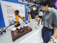 Visitors visit a ''tea art robot'' at the 2024 World Robot Conference in Beijing, China, on August 22, 2024. (