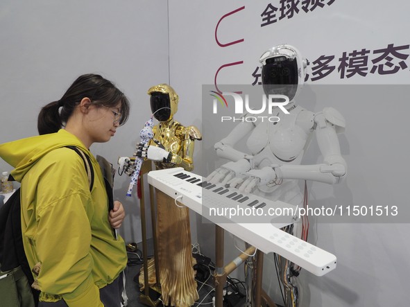 Visitors visit a ''piano robot'' at the 2024 World Robot Conference in Beijing, China, on August 22, 2024. 