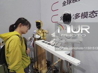 Visitors visit a ''piano robot'' at the 2024 World Robot Conference in Beijing, China, on August 22, 2024. (