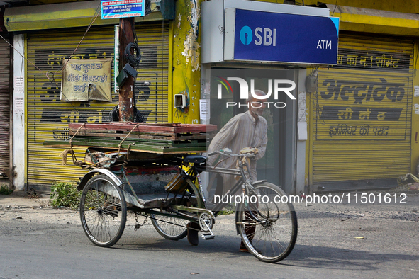 A man pushes a rickshaw loaded with wooden frames in Haldwani, Uttarakhand, India, on April 23, 2024. 