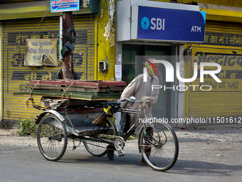 A man pushes a rickshaw loaded with wooden frames in Haldwani, Uttarakhand, India, on April 23, 2024. (