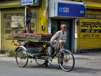 A man pushes a rickshaw loaded with wooden frames in Haldwani, Uttarakhand, India, on April 23, 2024. (