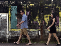 Foreign tourists walk past wall art depicting a fading Sri Lanka flag near Colombo, Sri Lanka, on August 23, 2024. According to a world repo...