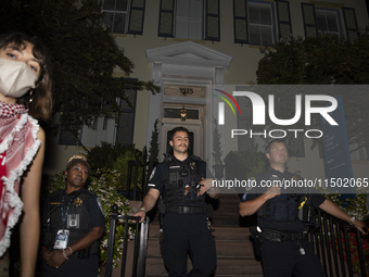 Police officers stand in front of GWU President Ellen Granberg's house during a pro-Palestinian demonstration at George Washington Universit...