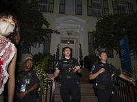 Police officers stand in front of GWU President Ellen Granberg's house during a pro-Palestinian demonstration at George Washington Universit...