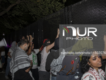 Protesters try to break the security fence at George Washington University in Washington, D.C., on August 22, 2024, while joining a pro-Pale...