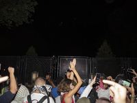 Protesters try to breach the security fence at George Washington University in Washington, D.C., United States, on August 22, 2024, while jo...