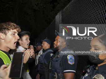 Police officers stop protesters from breaking the fence at George Washington University in Washington, D.C., on August 22, 2024, during a pr...