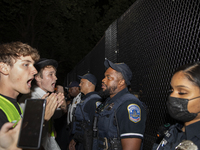 Police officers stop protesters from breaking the fence at George Washington University in Washington, D.C., on August 22, 2024, during a pr...