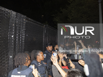 Police officers stop protesters from breaking the fence at George Washington University in Washington, D.C., on August 22, 2024, during a pr...