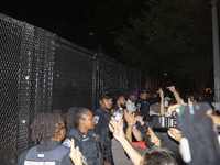 Police officers stop protesters from breaking the fence at George Washington University in Washington, D.C., on August 22, 2024, during a pr...