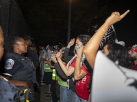 Police officers stop protesters from breaking the fence at George Washington University in Washington, D.C., on August 22, 2024, during a pr...