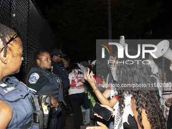 Police officers stop protesters from breaking the fence at George Washington University in Washington, D.C., on August 22, 2024, during a pr...