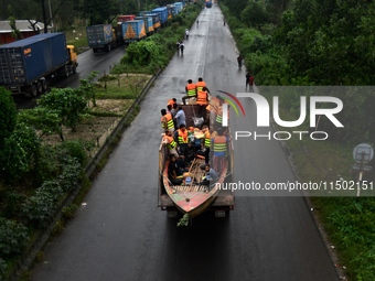 Volunteers carry a boat on a truck to help flood-affected people in Comilla, Bangladesh, on August 23, 2024. (