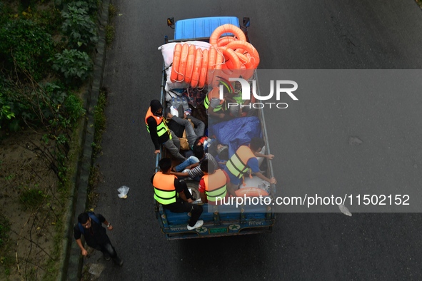 Volunteers carry life-saving gadgets on a truck to help flood-affected people in Comilla, Bangladesh, on August 23, 2024. 