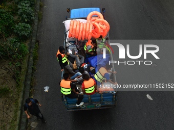 Volunteers carry life-saving gadgets on a truck to help flood-affected people in Comilla, Bangladesh, on August 23, 2024. (