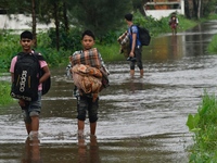 People wade through floodwater in Feni, Chittagong, Bangladesh, on August 23, 2024. (