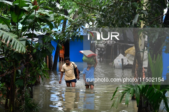 Local residents shift to temporary shelter homes as floodwater rises in their homes in Feni, Chittagong, Bangladesh, on August 23, 2024. 