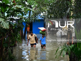 Local residents shift to temporary shelter homes as floodwater rises in their homes in Feni, Chittagong, Bangladesh, on August 23, 2024. (