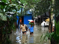 Local residents shift to temporary shelter homes as floodwater rises in their homes in Feni, Chittagong, Bangladesh, on August 23, 2024. (