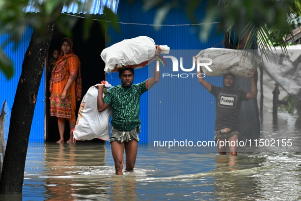 Local residents shift to temporary shelter homes as floodwater rises in their homes in Feni, Chittagong, Bangladesh, on August 23, 2024. 