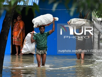 Local residents shift to temporary shelter homes as floodwater rises in their homes in Feni, Chittagong, Bangladesh, on August 23, 2024. (