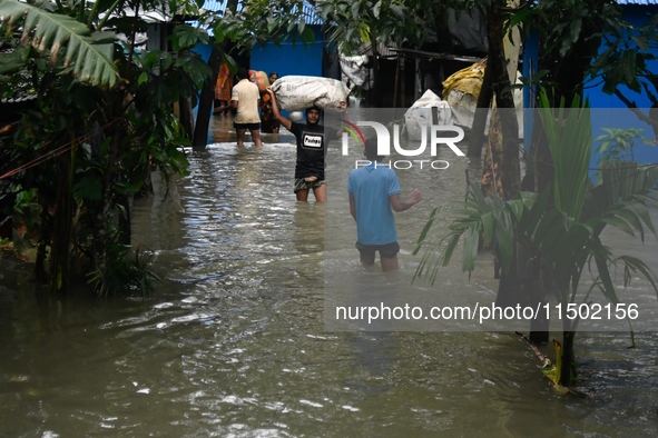 Local residents shift to temporary shelter homes as floodwater rises in their homes in Feni, Chittagong, Bangladesh, on August 23, 2024. 