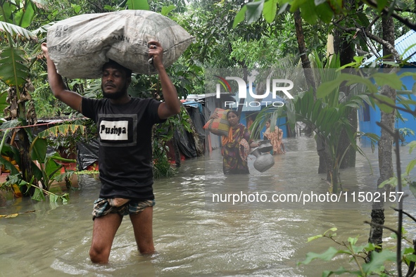 Local residents shift to temporary shelter homes as floodwater rises in their homes in Feni, Chittagong, Bangladesh, on August 23, 2024. 