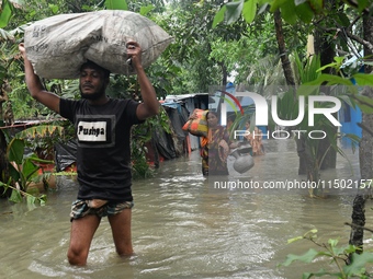 Local residents shift to temporary shelter homes as floodwater rises in their homes in Feni, Chittagong, Bangladesh, on August 23, 2024. (