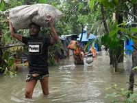 Local residents shift to temporary shelter homes as floodwater rises in their homes in Feni, Chittagong, Bangladesh, on August 23, 2024. (