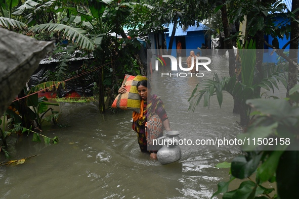 Local residents shift to temporary shelter homes as floodwater rises in their homes in Feni, Chittagong, Bangladesh, on August 23, 2024. 