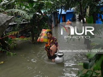 Local residents shift to temporary shelter homes as floodwater rises in their homes in Feni, Chittagong, Bangladesh, on August 23, 2024. (